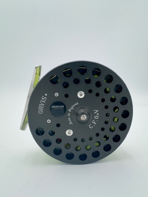 Orvis CFO V fishing reel showcasing a compact design with a sleek black finish and vibrant green highlights.