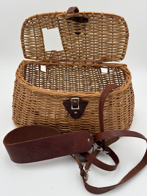 Orvis wicker basket with leather strap, perfect for organizing fishing tackle and outdoor activities.